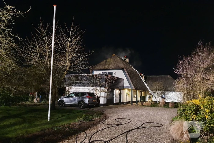 Brand in dak van villa met rietendak
