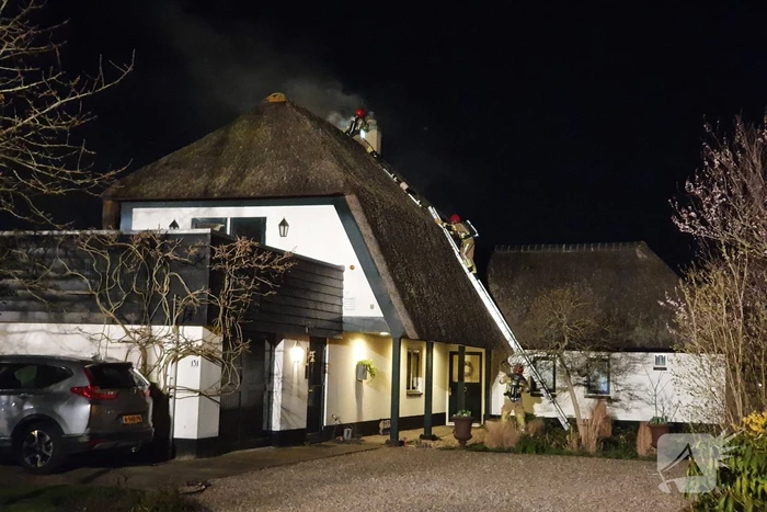 Brand in dak van villa met rietendak