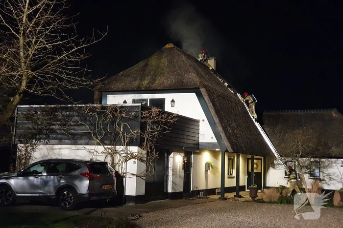 Brand in dak van villa met rietendak