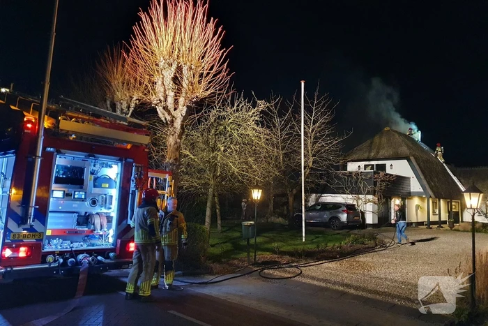 Brand in dak van villa met rietendak