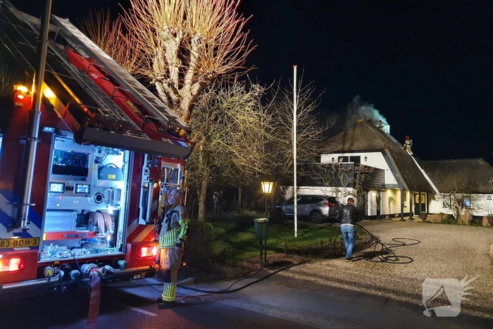 Brand in dak van villa met rietendak