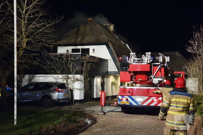 Brand in dak van villa met rietendak
