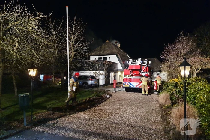 Brand in dak van villa met rietendak