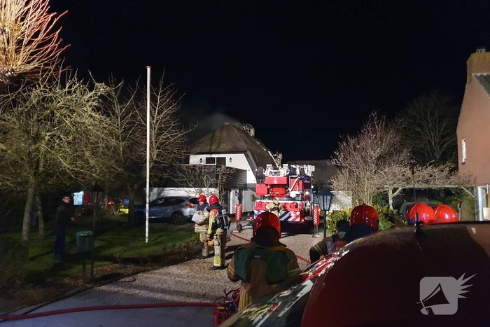 Brand in dak van villa met rietendak