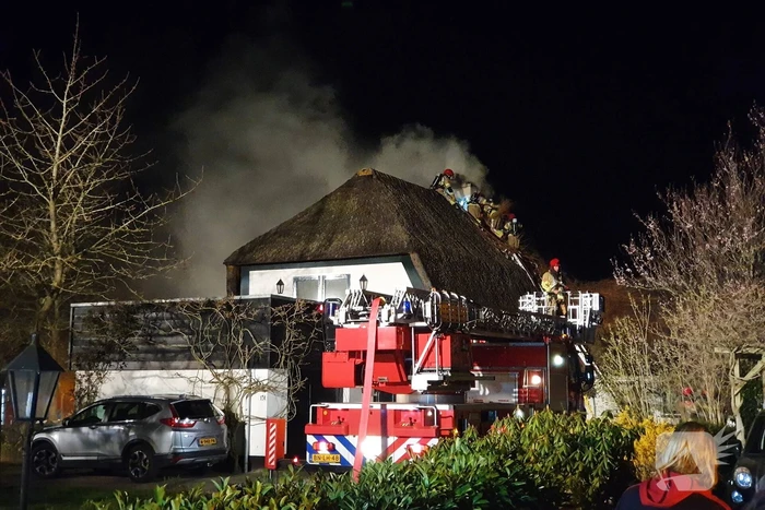 Brand in dak van villa met rietendak