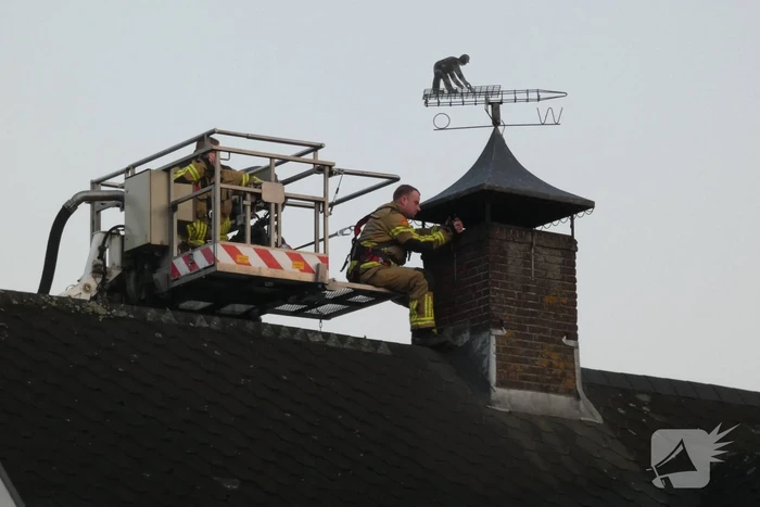 Brandweer blust brand in schoorsteen