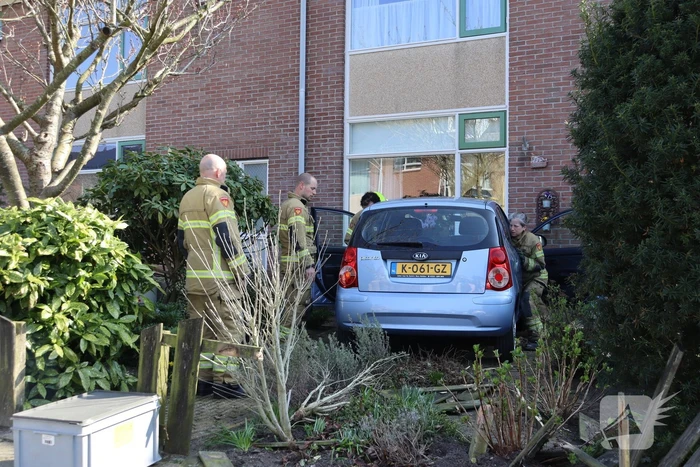 Auto rijdt voortuin van huis binnen
