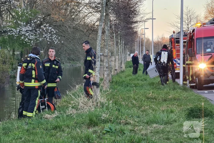 Driewieler aan waterkant, duikers zoeken naar slachtoffer