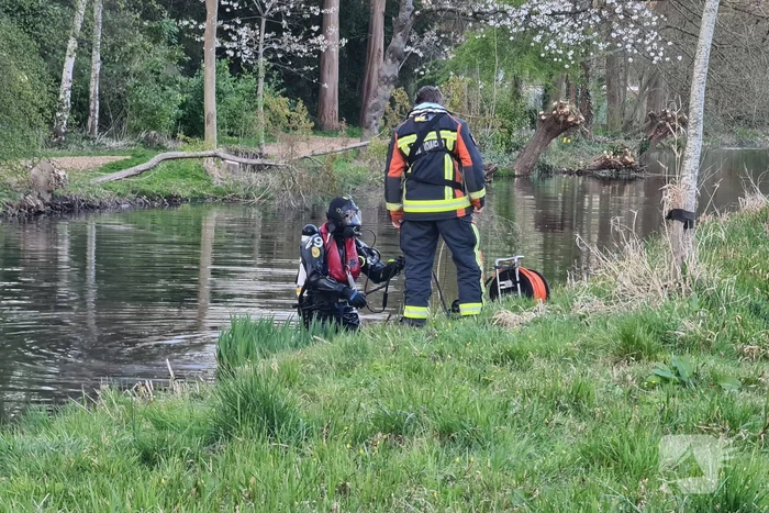 Driewieler aan waterkant, duikers zoeken naar slachtoffer