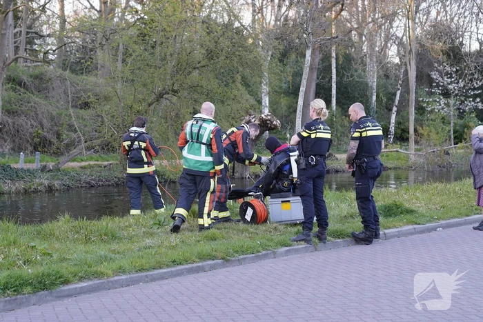 Driewieler aan waterkant, duikers zoeken naar slachtoffer
