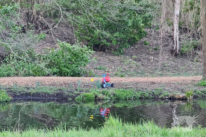 Driewieler aan waterkant, duikers zoeken naar slachtoffer
