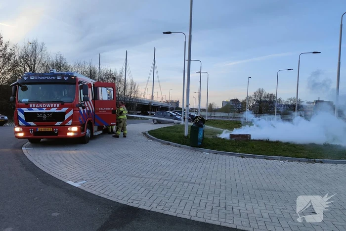 Brandweer blust brandende afvalcontainer