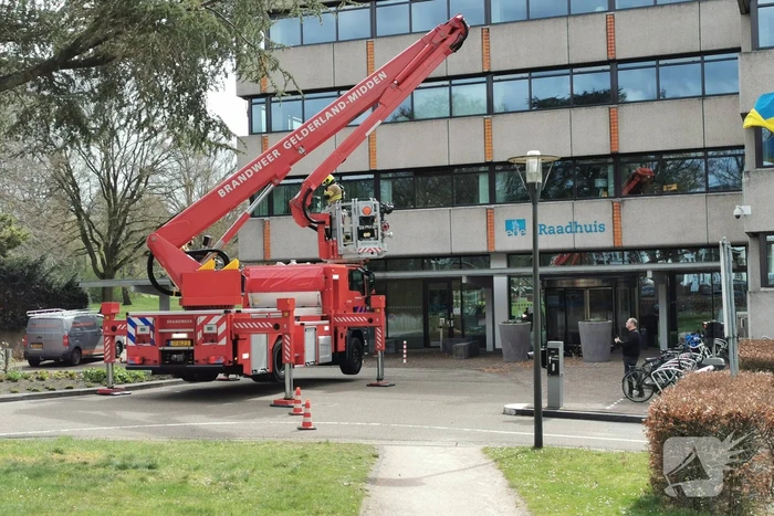 Brandweer zaagt gevaarlijk hangende tak uit boom voor gemeentehuis