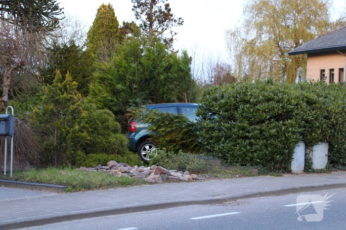 Auto rijdt achteruit voortuin van woning in
