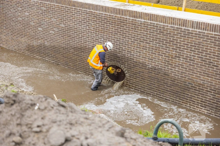 Water spuit uit nieuwe kademuur door gesprongen waterleiding
