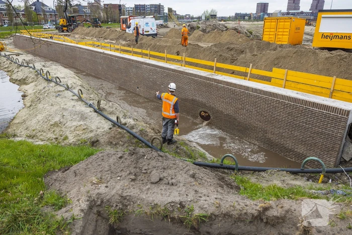 Water spuit uit nieuwe kademuur door gesprongen waterleiding