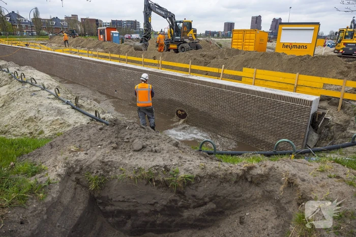 Water spuit uit nieuwe kademuur door gesprongen waterleiding