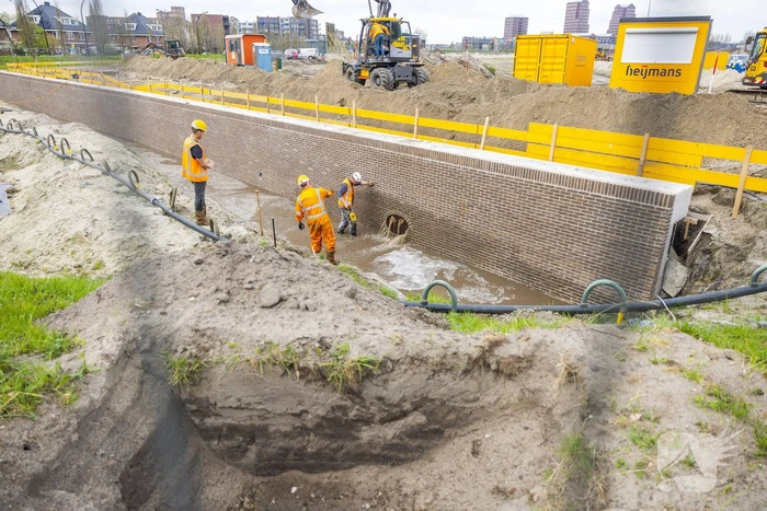 Water spuit uit nieuwe kademuur door gesprongen waterleiding