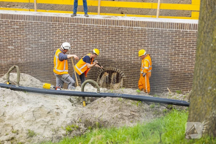 Water spuit uit nieuwe kademuur door gesprongen waterleiding