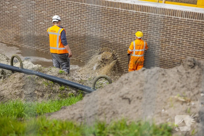 Water spuit uit nieuwe kademuur door gesprongen waterleiding