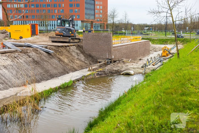 Water spuit uit nieuwe kademuur door gesprongen waterleiding