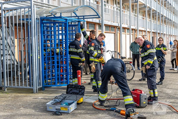 Kind met hoofd vast tussen draaideur