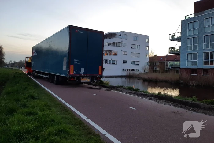 Vrachtwagen rijdt zich vast in berm