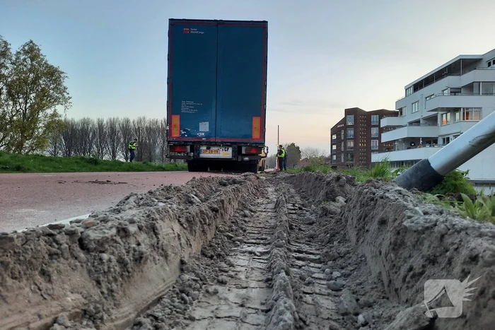 Vrachtwagen rijdt zich vast in berm