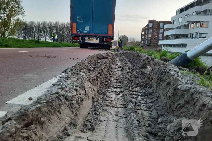 Vrachtwagen rijdt zich vast in berm