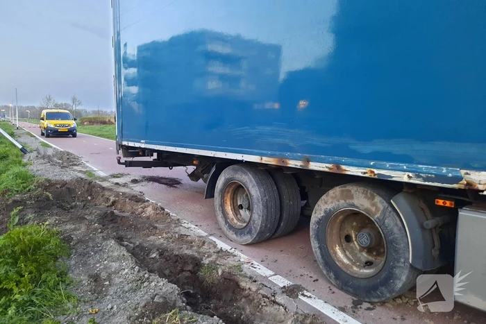 Vrachtwagen rijdt zich vast in berm
