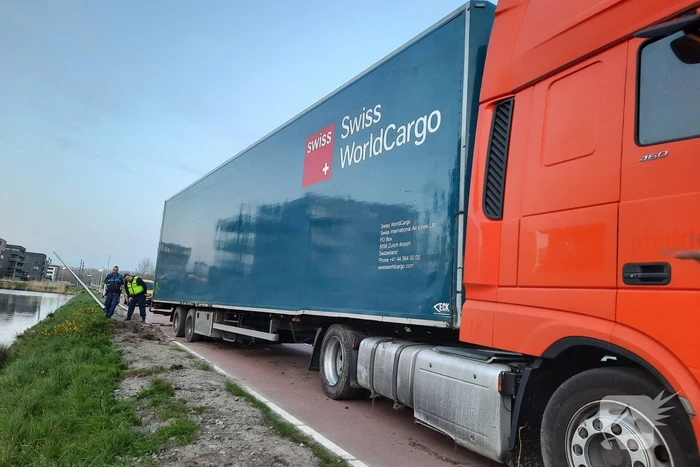 Vrachtwagen rijdt zich vast in berm