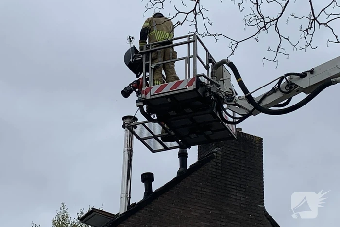 Brandweer veegt schoorsteen na brand