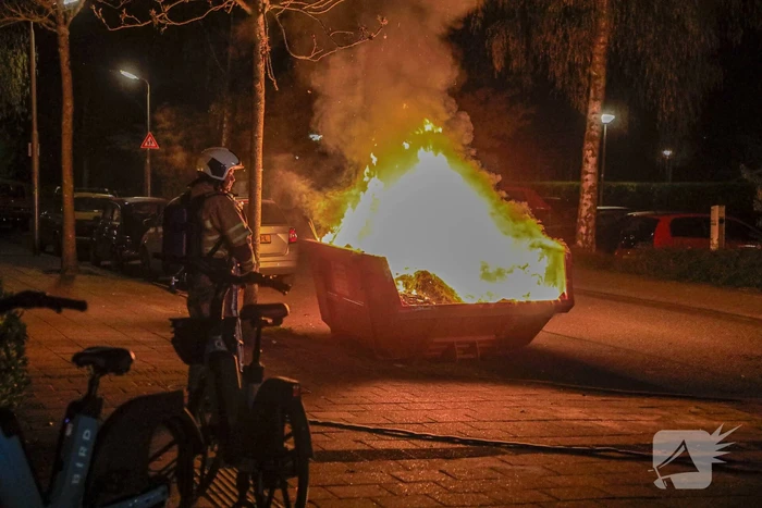 Vonken en rookontwikkeling bij brand in bouwafval container