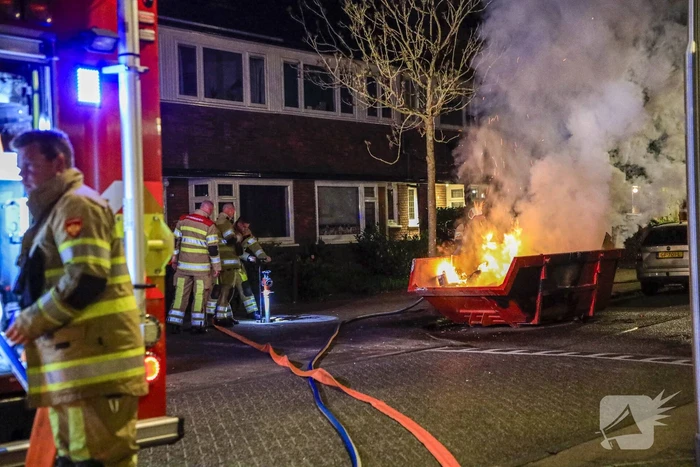 Vonken en rookontwikkeling bij brand in bouwafval container