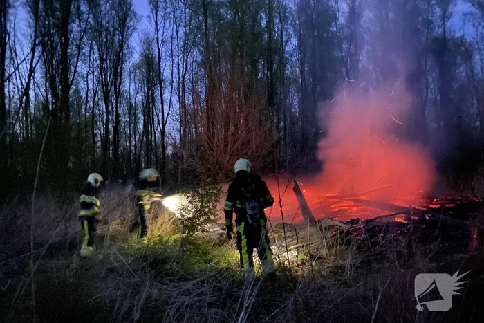 Stapel met hout vliegt in brand