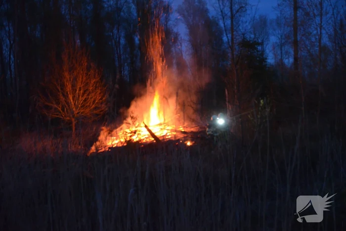 Stapel met hout vliegt in brand