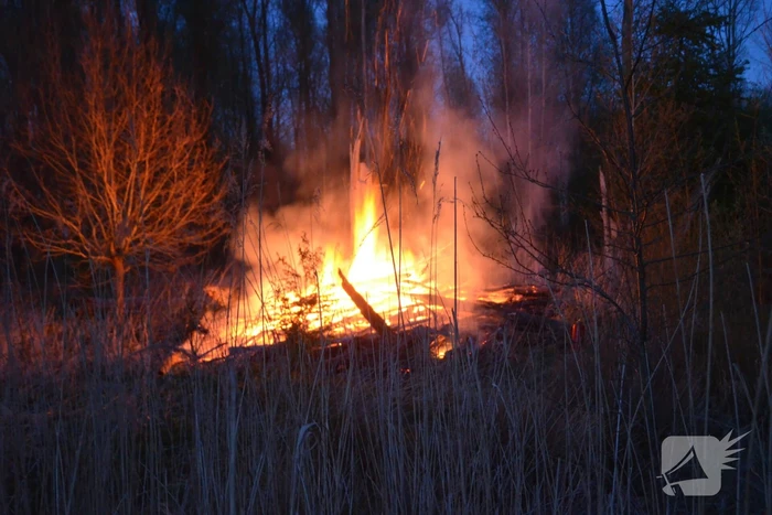 Stapel met hout vliegt in brand