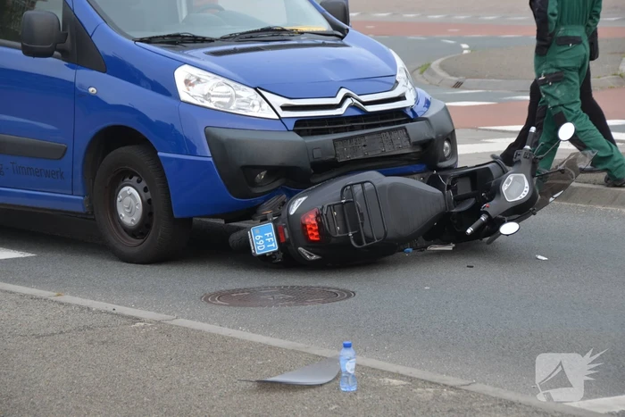 Scooter belandt onder bestelbus