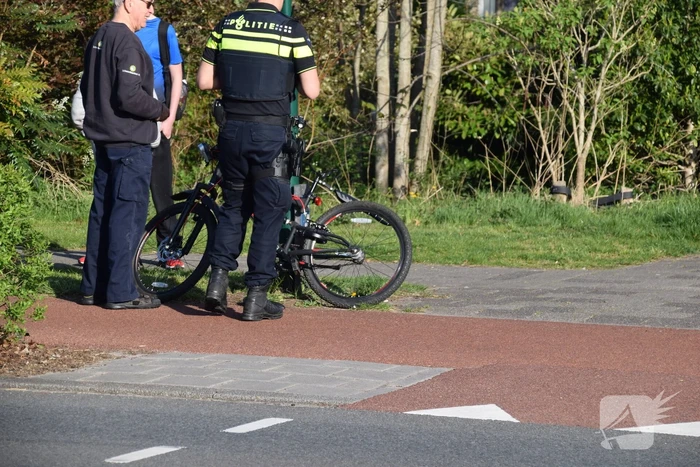 Jongeman op fiets vliegt over motorkap van auto