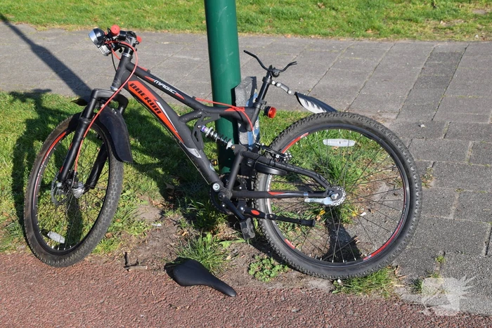 Jongeman op fiets vliegt over motorkap van auto
