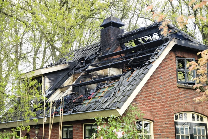 Vlammen slaan uit dak van vrijstaande woning