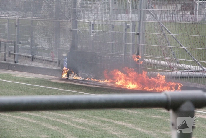 Vlammen bij brand naast sportveld