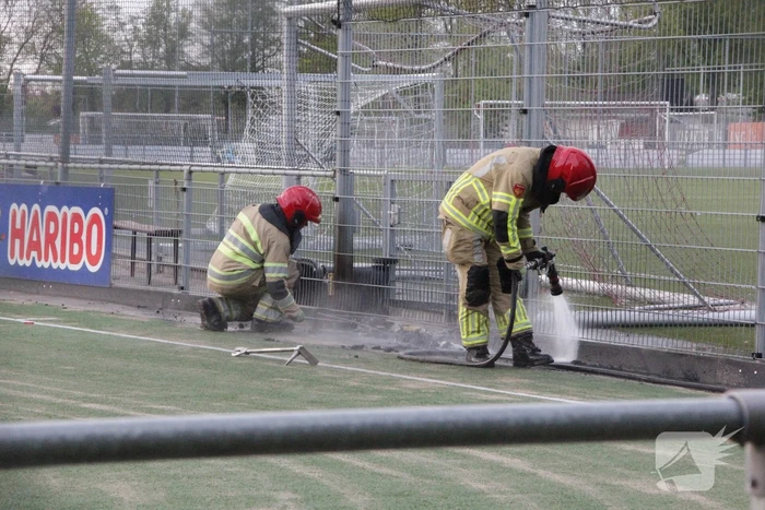 Vlammen bij brand naast sportveld