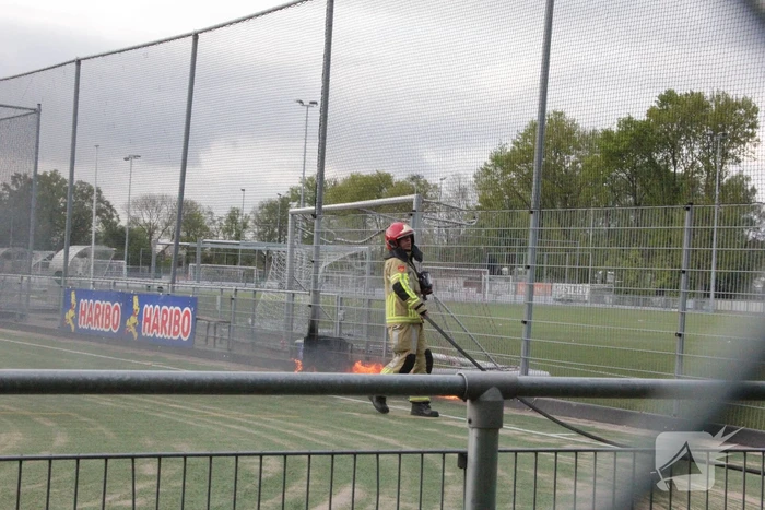 Vlammen bij brand naast sportveld
