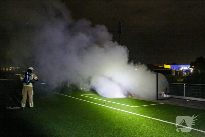 Vlammen op voetbalveld vanwege brand in afvalcontainer