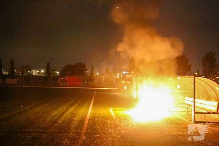 Vlammen op voetbalveld vanwege brand in afvalcontainer