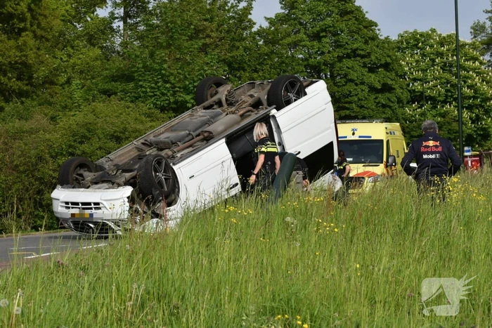 Bestelbus botst tegen paal en slaat over de kop