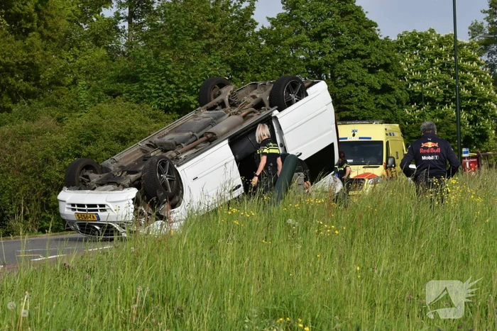 Bestelbus botst tegen paal en slaat over de kop