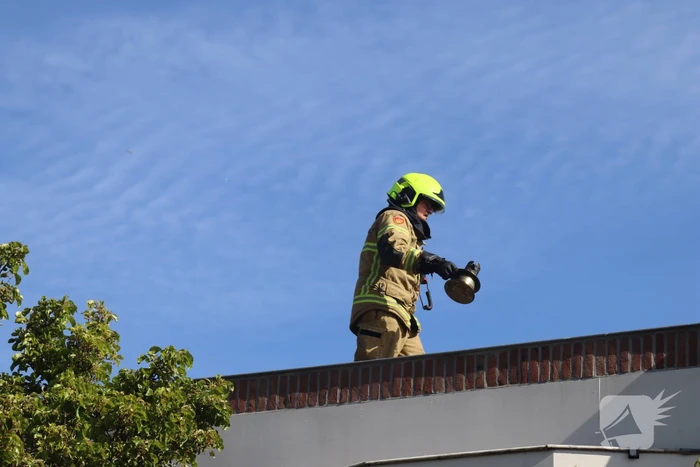 Brandweer veegt schoorsteen na brand