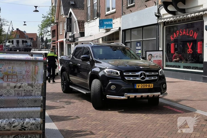 Voetganger aangereden door auto in winkelstraat